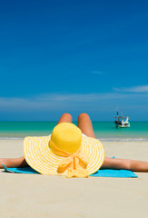 Fit woman in sun hat and bikini at beach