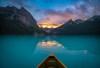 Viewing snowy mountain in rising sun from a canoe - obrazy, fototapety, plakaty