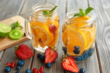 Refreshing water with fruits on table