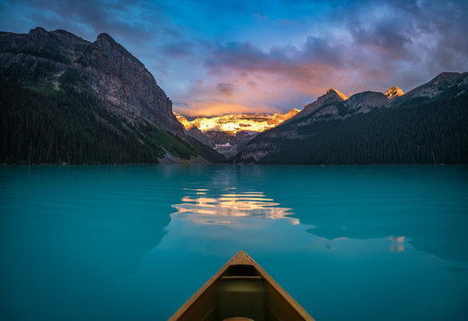 Viewing snowy mountain in rising sun from a canoe
