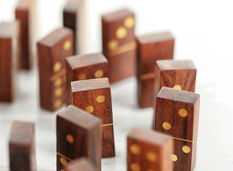 Circle of dominoes standing on light wooden background