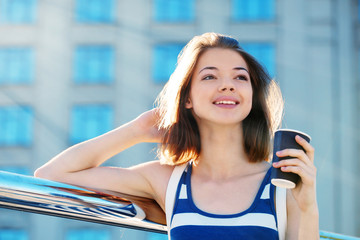 Young girl with coffee on a sunny day