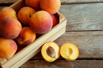 Naklejka na ściany i meble Fresh peaches in a box on a wooden background