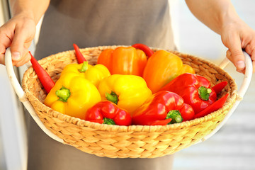 Woman holding fresh peppers in a basket