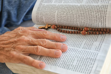 Old man holding and reading Bible