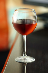 Glass with red wine on table