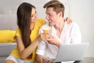 Beautiful couple surfing internet on laptop at home