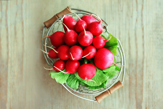 Fresh radish in basket on wooden table