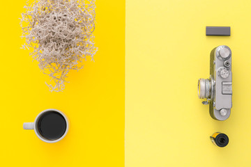 Yellow table of a creative designer or photographer with laptop, tablet, cameras. Stylish home studio concept of technology trends. View from above.