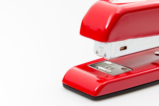 Red metal stapler close up on white background