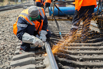 Obraz premium photo of worker doing gas cutting on rails