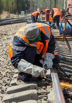 photo of worker doing gas cutting on rails