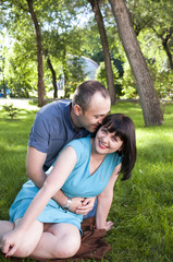 Fototapeta premium Man whispering compliments a woman's ear 