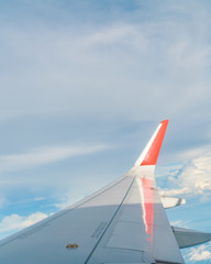 Wing of an airplane flying above the clouds .