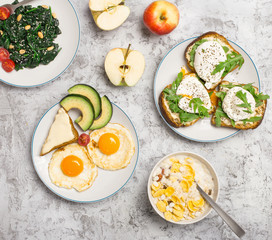 Helpful breakfast from different of dishes on light surface