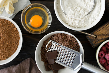 Food ingredients for cooking chocolate dessert on dark wooden ba