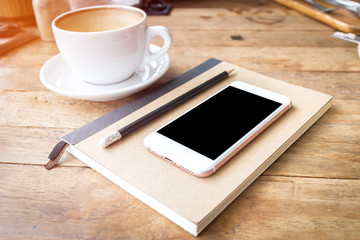 Fototapeta na wymiar Mobile phone and diary notebook with coffee cup on wood backgrou