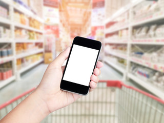 Female hand holding mobile smart phone on Supermarket blur backg