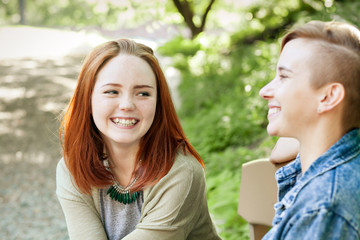 Obraz premium LGBT women. Young lesbian couple walking in the park together. Delicate relationship. Selective focus.
