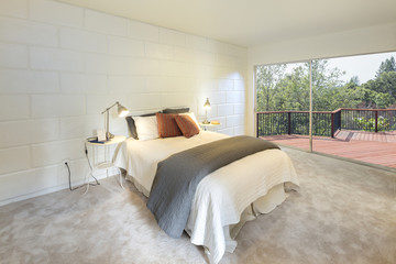 Modern bedroom with large window and deck.