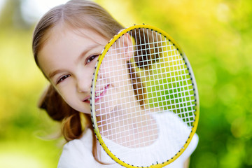 Cute little girl playing badminton outdoors
