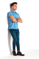 Fototapeta premium man leaning against studio wall with hands crossed