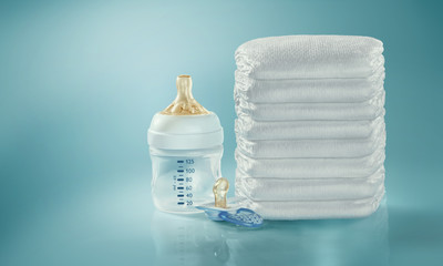 Stack of diapers. Baby bottle and pacifier. Studio Shot. Isolated

