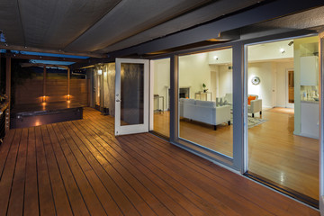 Amazing wooden deck at twilight with open french doors showing m