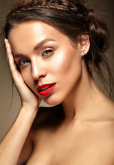 portrait of beautiful woman model with fresh daily makeup and red lips and healthy skin touching her cheek