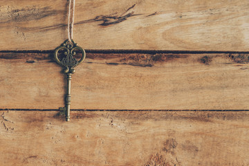 old key hanging on wood background texture with copy space