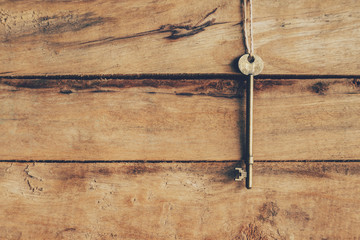 old key hanging on wood background texture with copy space
