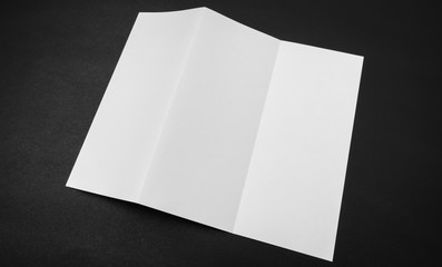 Trifold white template paper on black background .