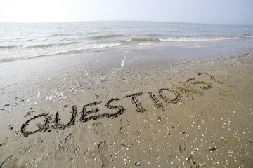 QUESTIONS with question mark written in large letters on the san