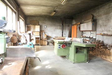 disused carpentry with the machine to cut the wooden planks - obrazy, fototapety, plakaty