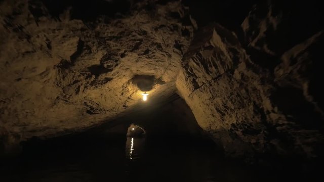 Excursion by boat through the dark cave system. Mysterious atmosphere of Vietnam nature