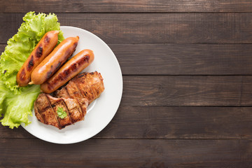 Top view BBQ Grilled meat, sausages and vegetables on dish.