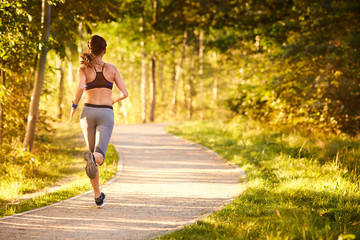 Fototapeta na wymiar Fit young woman running in park