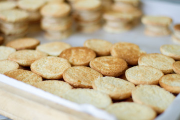 Fototapeta na wymiar Round yellow cookies. Lots of biscuits. Warm and crispy pastry. How to make easy dessert.