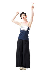 Fototapeta na wymiar Pretty short hair brunette in off the shoulder top with raised arms pointing up. Full body length portrait isolated over white studio background.