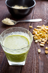 Healthy Avocado Protein Milkshake with Peanut Butter and Spinach on Dark Wooden Background