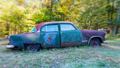 Abandoned car rusting in a field