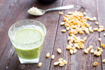 Green Protein Milkshake with Peanut Butter, Banana and Spinach on Dark Wooden Background