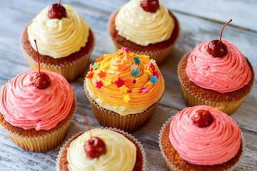 Cupcakes with frosting. Small colorful desserts. Easy recipe of tasty pastry. Soft dough and buttercream.