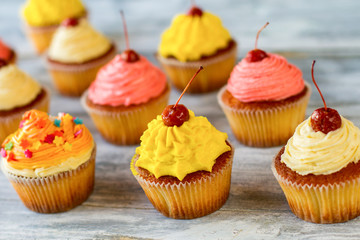 Bright-colored cupcakes. Baked desserts with icing. Recipe for great mood. Happiness has its taste.