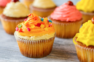 Bright-colored cupcake. Dessert with orange frosting. Best homemade pastry. Shape and flavor.