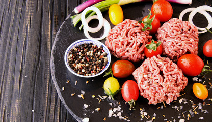 raw minced meat, vegetables with salt and spices, selective focus