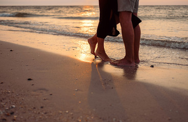 Close up image in love couple legs on sun rise sea side