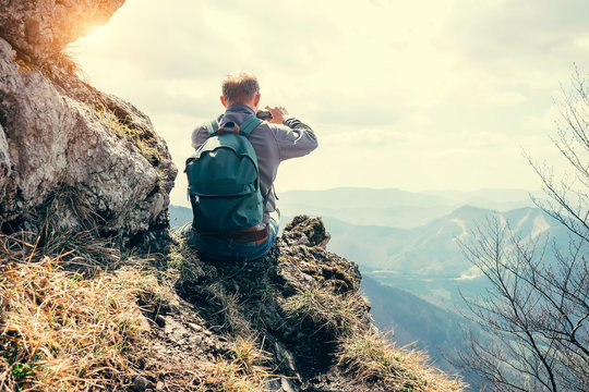 Climber take a mountain landscape photo on his smartphone