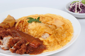 Omelet rice with deep fried chicken in Japanese yellow curry sserved with butter mashed potatoes salad  on white. Selective focus view.