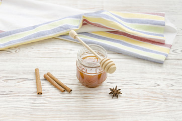 Jar of honey and stick with spices